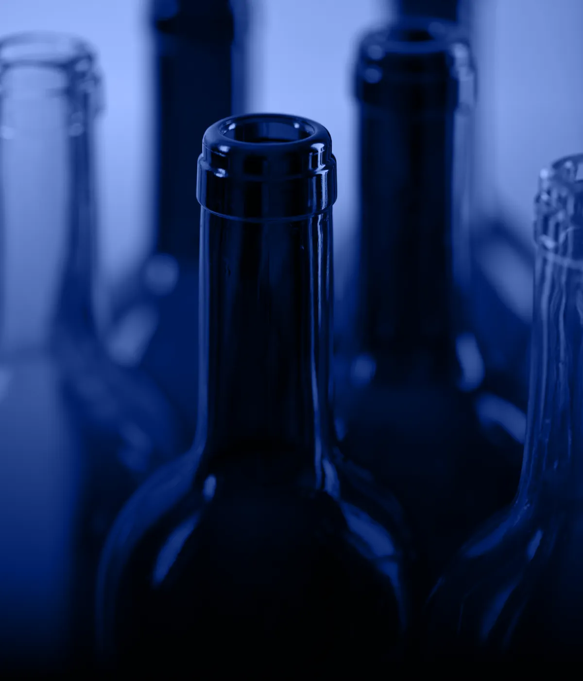 Стеклянные бутылки крупным планом в синем освещении